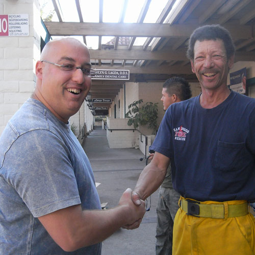 Dr. Klein with firefighter shaking hands